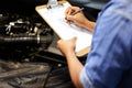 Hands, car mechanic and writing on checklist for service, maintenance and document repair list. Hand, man and engineer Royalty Free Stock Photo