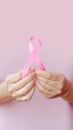 hands carefully holding symbol pink ribbon against a soft pink background breast cancer awareness.. Royalty Free Stock Photo