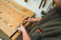 Hands of carpenter carefully drawing line using marker and ruler on wooden plank Royalty Free Stock Photo