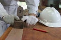 Hands of carpenter planing a plank of wood using a hand planer in carpentry workshop. Royalty Free Stock Photo