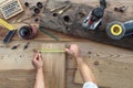 hands carpenter work the wood, measuring with tape meter old rustic wooden boards, top view with tools on background