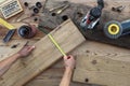 hands carpenter work the wood, measuring with tape meter old rustic wooden boards, top view with tools on background Royalty Free Stock Photo