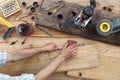 Hands carpenter working a wooden rustic old board with a sand pa