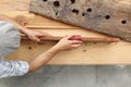 Hands carpenter working a wooden rustic old board with a sand pa