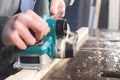 The hands of a carpenter working woodworking power tools. Close up of the work of the electric planer Royalty Free Stock Photo