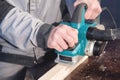 The hands of a carpenter working woodworking power tools. Close up of the work of the electric planer Royalty Free Stock Photo