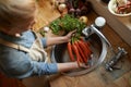 Hands, carrots and washing in sink for healthy vegetable for wellness ingredient or organic, salad or hygiene. Chef Royalty Free Stock Photo