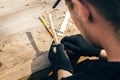 Hands carving spoon from wood, working with chisel close up. Process of making wooden spoon, chisel and shavings on dirty table. Royalty Free Stock Photo