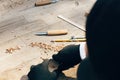 Hands carving spoon from wood, working with chisel close up. Wooden workshop. Process of making wooden spoon, chisel, pencil, Royalty Free Stock Photo