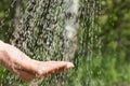 Hands catching clean falling water close up