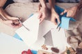 Hands of a caucasian girl and her brother are cutting paper snowflakes with scissors. Handmade, christmas decorations, family Royalty Free Stock Photo