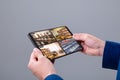 Hands of caucasian man holding tablet with view of library from security cameras on screen