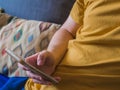 Overweight person using smartphone on couch Royalty Free Stock Photo