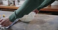 Hands of caucasian man uncovering bread dough in kitchen, slow motion