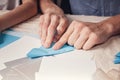 Hands of a caucasian teenager cutting paper snowflakes with scissors. Handmade, christmas decorations, family winter activity. Royalty Free Stock Photo