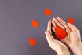 Hands of caucasian woman cupping blood drop, with blood drops on grey background, copy space