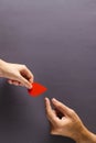 Hands of caucasian woman passing blood drop to caucasian man, on grey background with copy space Royalty Free Stock Photo