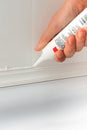 Hands caulking bath tube with white silicone glue Royalty Free Stock Photo