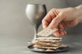 Hands with chalice and communion matzo bread, wooden cross on grey background. Christian communion for reminder of Jesus sacrifice Royalty Free Stock Photo