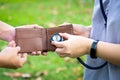 Hands checking open wallet with stethoscope in green nature,care of money problems,financial health care,money saving for medical Royalty Free Stock Photo