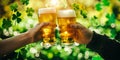 Hands cheer with Irish beer in green shamrocks background for St. Patrick& x27;s day festive