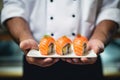 The hands of a chef holding a plate of freshly prepared sushi rolls - Japanese traditional food Royalty Free Stock Photo