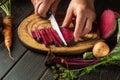 The hands of the chef with a knife cut the beets or beetroot for cooking vegetarian food for lunch Royalty Free Stock Photo