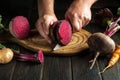 The hands of the chef with a knife cut the beets or beetroot for cooking vegetarian food for lunch. Peasant products. Copy space Royalty Free Stock Photo