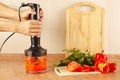 Hands chefs chopped red paprika in blender Royalty Free Stock Photo