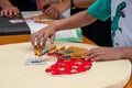 Hands of child and adult making bobbin lace. Colorful lace threads Royalty Free Stock Photo