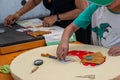 Hands of child and adult making bobbin lace. Colorful lace threads. Skill