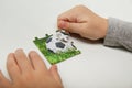 Hands of a child compile a puzzle with a soccer ball