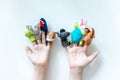 Hands of a child with finger puppets, toys, dolls close up on white background - playing puppet theatre and children entertainment