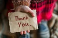 Hands of a child holding a card with thank you message.