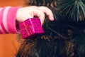 Hands of a child holding a small gift, decoration on a Christmas tree Royalty Free Stock Photo