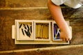 Hands of a child manipulating educational beads materials to learn to count in a Montessori classroom