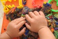 Hands of child playing multicolored kinetic sand. children activity game toy for model forming craft and sculpture art