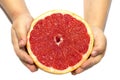 Hands child`s holding a red grapefruit on white isolated background. healthy food concept. Hands kid holding grapefruit. Royalty Free Stock Photo
