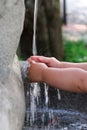 Hands of a child under the water of a fountain Royalty Free Stock Photo