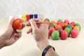 Hands of christian holding eggs and coloring with paint brush on table with copy space background.