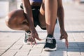 Hands, city and athlete tie shoes to start workout, training and exercise outdoor. Sports, fitness and person tying