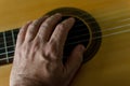 Hands of a classical guitarist on top of the guitar. Study of classical music