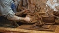 The hands of a clay artisan seen at his warehouse working on a vase