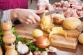 Hands cleaning potatoes at table in kitchen