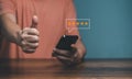 Hands of Client holding and giving a Five Star Rating feedback and raised thumbs up Royalty Free Stock Photo