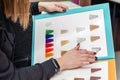 Hands of client holding palette of hair dye samples Royalty Free Stock Photo
