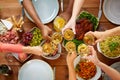 Hands clinking wine glasses over table with food Royalty Free Stock Photo