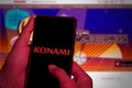 Hands close up. This photo illustration shows the logo of the Japanese company Konami Group Corporation on a cellphone screen