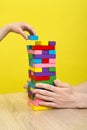 Hands close up playing a round of jenga or tower with wooden blocks. Planning, risk and strategy in business or building Royalty Free Stock Photo