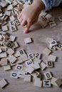 hands close-up, small child 3 years old plays wooden alphabet blocks, makes up words from letters, dyslexia awareness, learning